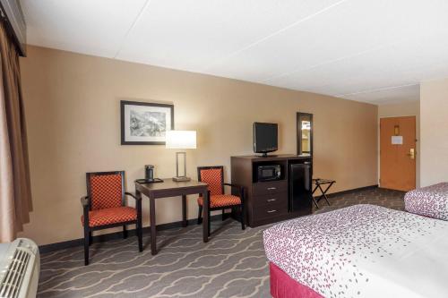 a hotel room with a desk and chairs and a tv at Best Western Inn at Blakeslee-Pocono in Blakeslee