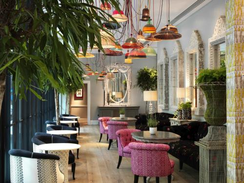 a restaurant with pink chairs and tables and plants at Ham Yard Hotel, Firmdale Hotels in London