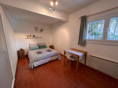 une chambre avec un lit, un bureau et une fenêtre dans l'établissement SIMONE, Appartement maison, quartier calme, grande terrasse, SPA, barbecue, 2 chambres, à Fréjus