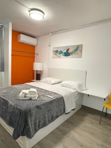 ein kleines Schlafzimmer mit einem Bett und einem gelben Stuhl in der Unterkunft Caribbean Stars in Carolina