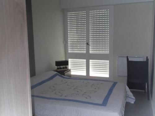 Schlafzimmer mit einem Bett vor einem Fenster in der Unterkunft Les Mouettes St Hilaire in Saint-Hilaire-de-Riez