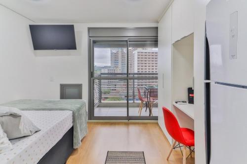 Un dormitorio pequeño con una cama y un refrigerador. en 717 - Rentaqui Studio Elegance Butanta, en São Paulo