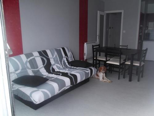 einem Hund, der in einem Wohnzimmer auf dem Boden sitzt in der Unterkunft Les Mouettes St Hilaire in Saint-Hilaire-de-Riez