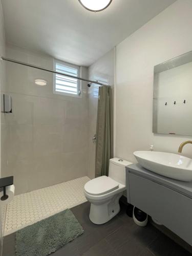 biała łazienka z toaletą i umywalką w obiekcie Caribbean Stars w mieście Carolina