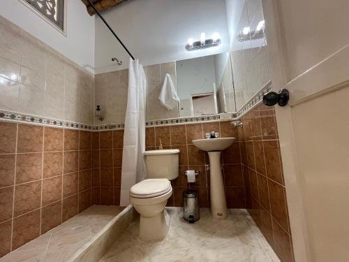 a bathroom with a toilet and a sink at Finca Hotel San Miguel in Calarcá