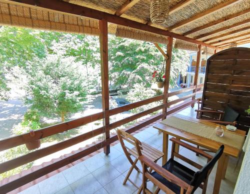 a porch with a wooden table and two chairs at Sotiria Apartments in Kokkino Nero