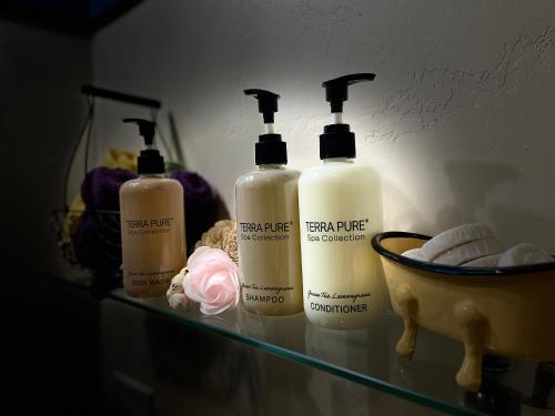 a shelf with four bottles of hair products on it at IreneHouse Victorian INN in Sacramento