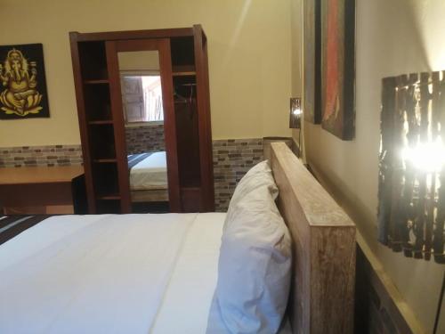 a bedroom with a bed and a room with a mirror at Canggu Pinpoint Rooms in Canggu