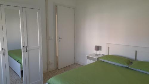波爾托格魯阿羅的住宿－Villa Cecilia，一间卧室配有绿色的床和镜子