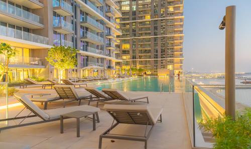 a swimming pool with lounge chairs and a building at YOUR STAY APARTMENTS in Dubai
