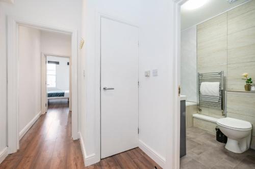 a white bathroom with a toilet and a sink at Beautiful Flat Near the Center 11 min by tube in London