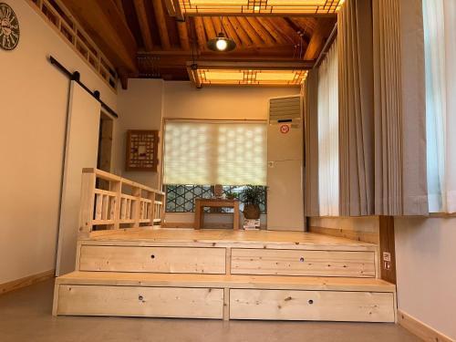 a large wooden platform in a room with a window at Sarangroo in Jeonju