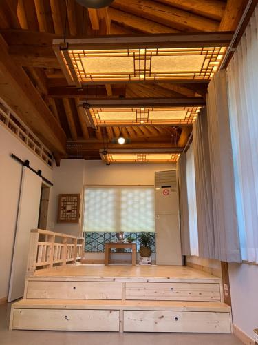 an empty room with a large window and wooden ceilings at Sarangroo in Jeonju