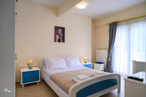 a bedroom with a bed with two tables and a window at Luxury Villa King George in Nea Makri in Nea Makri