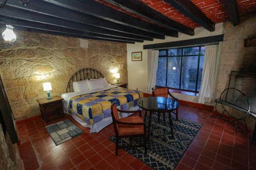 a bedroom with a bed and a table in a room at Hotel Hacienda San Miguel Regla in Huasca de Ocampo