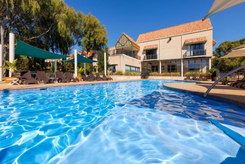 a swimming pool at a resort with chairs and a building at Club Wyndham Dunsborough, Trademark Collection by Wyndham in Dunsborough