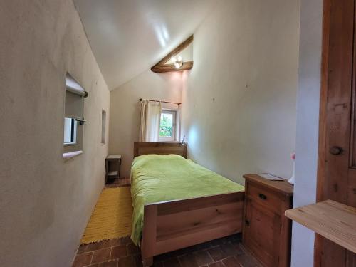 Un dormitorio con una cama verde y una ventana en Domaine Moulin de Boiscorde 1h45 Paris en Rémalard