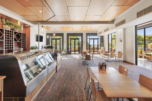 a restaurant with wooden tables and chairs and windows at Club Wyndham Dunsborough, Trademark Collection by Wyndham in Dunsborough