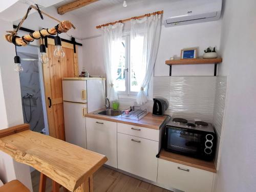 a small kitchen with a sink and a microwave at Sotiria Apartments in Kókkinon Nerón