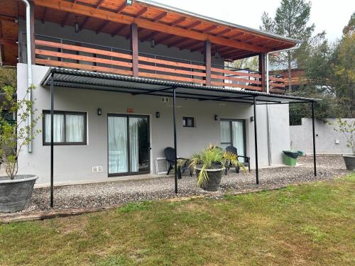 a house with a screened in porch in a yard at Chalets de la paix in Santa Rosa de Calamuchita