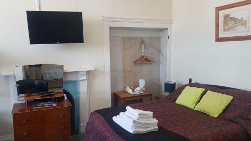 スランディドノにあるOverton Villa Hotelのベッドとテレビ付きのホテルルーム