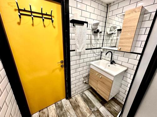 baño con puerta amarilla y lavamanos en Golden Prince Hotel Taksim en Taksim