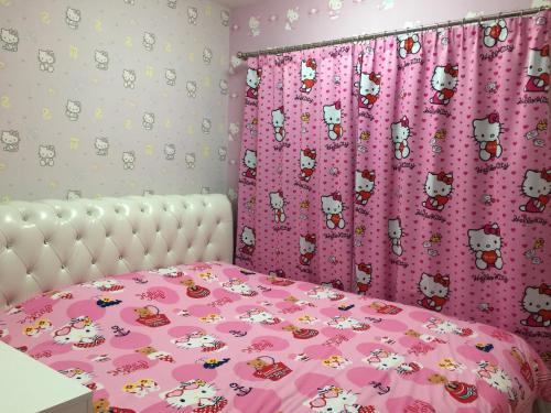 a bedroom with a bed with a pink comforter and curtains at The Trust Hua Hin kitty room in Hua Hin