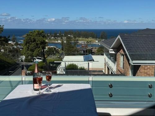 a bottle of wine and two glasses on a table at The Eagles Nest in Kiama