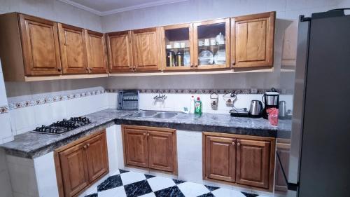 丹吉尔Luxury Sea and Marina View Apartment的厨房配有木制橱柜,铺有黑白瓷砖地板。