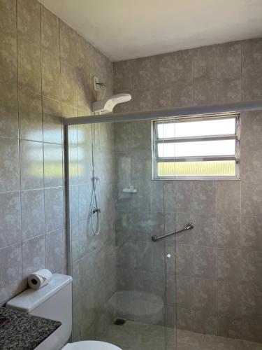 uma casa de banho com um chuveiro, um WC e uma janela. em Vilage Bed & Breakfast em Volta Redonda