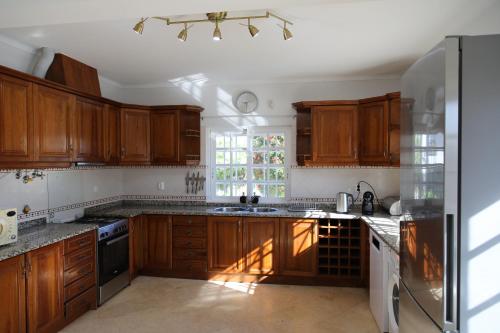 a kitchen with wooden cabinets and a window at Casa vista Arrabida in Cotovia