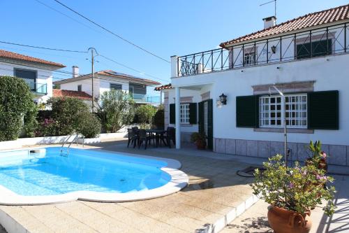 a swimming pool in front of a house at Casa vista Arrabida in Cotovia