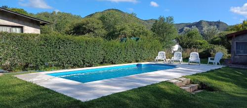 a swimming pool with two lawn chairs at Schönes Loft in Villa General Belgrano