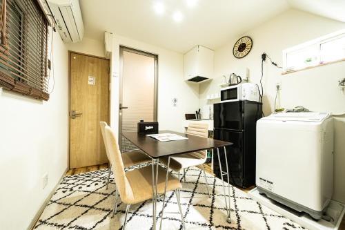 a small kitchen with a table and a refrigerator at 18, Oji B, Detached house for rent, 王子B in Tokyo