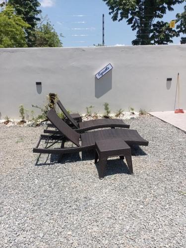 two benches and a picnic table next to a wall at Villa Ybelis Paradise in Concepción de La Vega