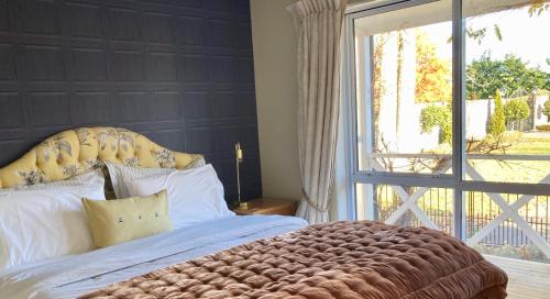 una camera da letto con un grande letto con una grande finestra di Willow Tree Cottage a Lincoln
