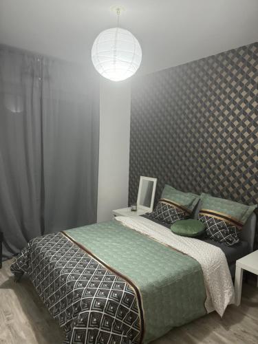 une chambre avec un grand lit et une lampe dans l'établissement Stade de France métro RER, à Aubervilliers