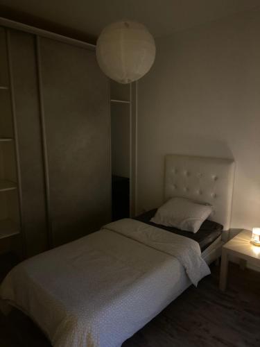 - une petite chambre avec un lit et une lampe dans l'établissement Stade de France métro RER, à Aubervilliers