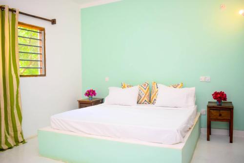 sypialnia z białym łóżkiem i oknem w obiekcie Shoreline Serenity in Malindi w mieście Malindi