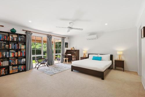 una camera con letto, scrivania e libreria di Spacious 4-Bed Hinterland Luxury Escape with Pool a Gold Coast