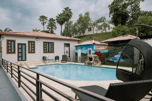 a swimming pool with a swing and a house at Casa Campo Bed & Breakfast in San Sebastian