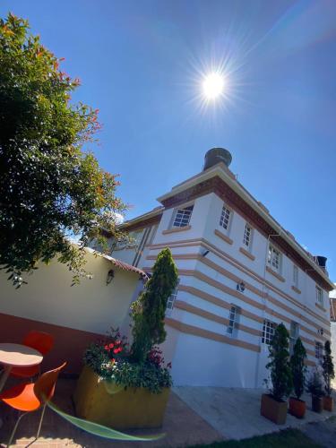 a white building with the sun in the sky at Hotel Villa Mercedes Colonial in Sopó