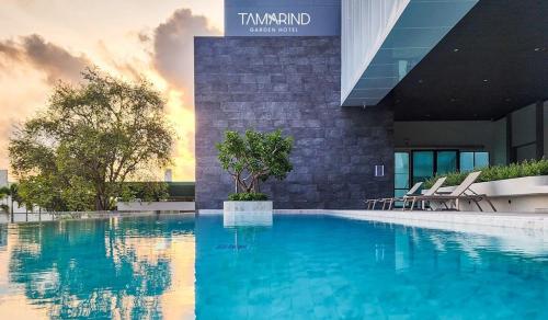 a large swimming pool in front of a building at Tamarind Garden Hotel - SHA Plus Certified in Rayong