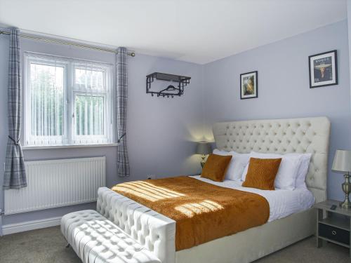 Un dormitorio con una gran cama blanca y una ventana en Luxe 5 Bed Bungalow In Snodland, Medway, Kent en Kent