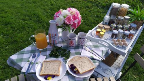 a picnic table with sandwiches and eggs and flowers at Taranaki Creekside TUI by Tiny Away in Stratford