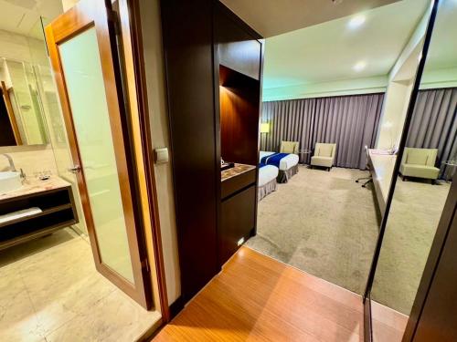 花蓮市にあるHiYesHotel勤天商旅-花蓮館のバスルームとベッドルームが備わるホテルルームです。
