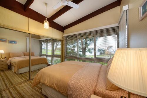 een slaapkamer met 2 bedden en een groot raam bij Pebble Views by Property Mums in Flinders