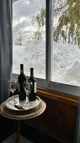 a table with two bottles of wine and two glasses at Hostal Boutique CUMBRES in Farellones