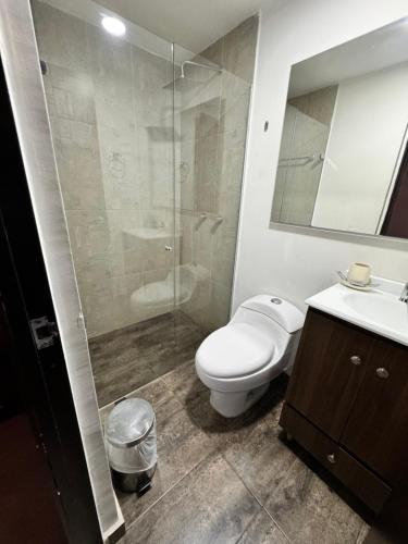 メデジンにあるApartamento Poblado en la zona rosa de medellínのトイレとガラスのシャワー付きのバスルーム