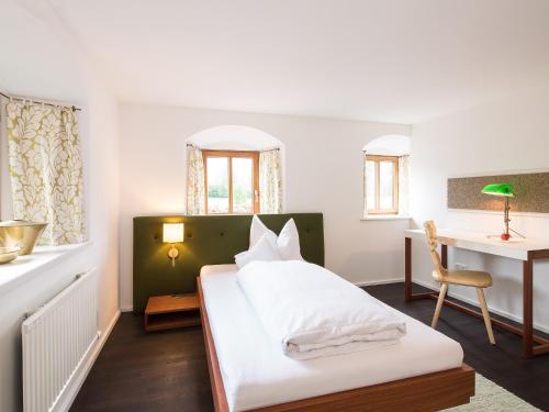 a bedroom with a bed and a desk and a table at Gasthof Schopper in Breitenbach am Inn